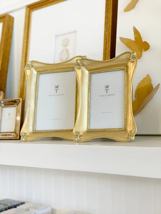 &nbsp;Brocante Distressed Gold Leaf Photo Frames measure 4 x 6, and 5 x 7 inches and available in 2 styles. Classic and elegant, these golden brocante frames will add an extra oomph you didn't know you needed. Gorgeous from front to back, these frames are a must-have. Backed with an easel prop stand for tabletop display. Made of resin and porcelain.